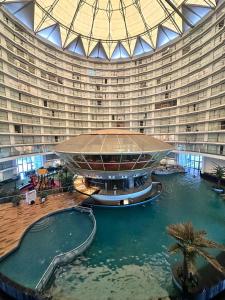 a large building with a swimming pool in front of it at 7 Star homes at Rajhans Belliza in Surat