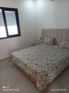 a bedroom with a bed with a comforter and a window at Villa Léann in Mezraya +14 photos