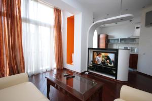 شقق رييل هوم إن كييف سنتر في كييف: غرفة معيشة مع تلفزيون وأريكة