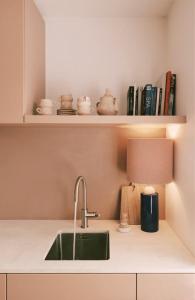 eine Küchentheke mit Spüle und Lampe in der Unterkunft SUNSET, Maison Littoral by BLOSS, stylish family apartment near the beach with terrace in De Haan + 20 Fotos