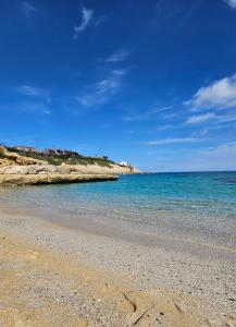 una spiaggia con l'oceano e un cielo azzurro di Mary's Rooms a Porto Torres