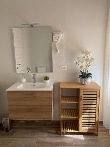 un bagno con lavandino e specchio di Mary's Rooms a Porto Torres