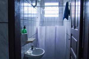 un bagno bianco con lavandino e doccia di Casinha Aconchegante a Ouro Preto