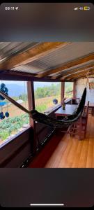 a hammock in a room with two windows at Panchase Family Homestay in Pokhara