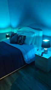 una camera da letto blu con un letto e un comodino di Mary's Rooms a Porto Torres