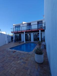 una casa con piscina delante de un edificio en The White House - Zonnebloem, en Ciudad del Cabo