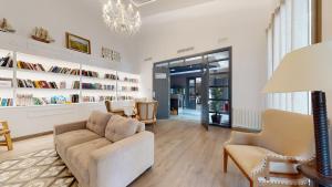 a living room with a couch and chairs and bookshelves at Bellevall resort, hotel y apartamentos in Aspe