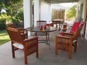 a patio with a table and chairs on a porch at Geduld in Prince Albert