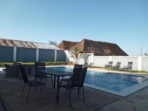 a patio with a table and chairs next to a pool at Paje Home away from home in Paje
