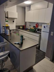 a kitchen with white cabinets and a white refrigerator at Superbe appartement à koksijde (coxyde) in Koksijde