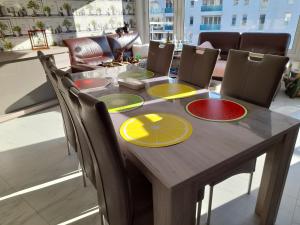 a dining room table with yellow and red plates on it at Superbe appartement à koksijde (coxyde) in Koksijde