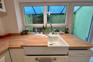 a kitchen with a sink and a large window at Beautiful apartment of 67 m2 near Strasbourg in Bischheim