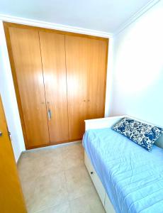 a small bedroom with a bed and wooden cabinets at Olivia in Barrio-Mar