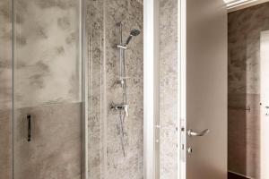 a shower with a glass door in a bathroom at Padova living Experience - Diamante Apartment, Rubino Room and Smeraldo Room in Padova +22 photos