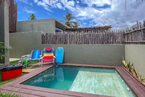 a small swimming pool with chairs and a fence at Paraíso Patacho Riviera Casa 01 Villa 04 in Pôrto de Pedras