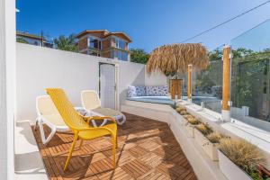 a patio with two yellow chairs and a pool at Villa Kalimera in Balchik