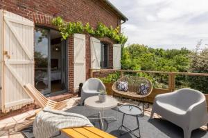 a patio with chairs and tables on a balcony at Le gîte du Papillon - Normandy Holiday Cottage in Neufchâtel-en-Bray