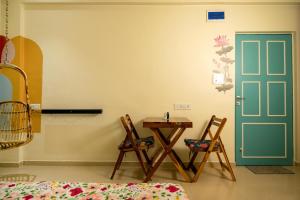 a room with a table and chairs and a door at La Mira Casa Karjat in Karjat +14 photos