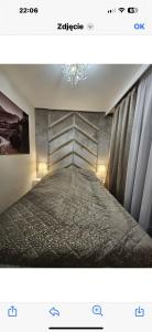a bedroom with a bed and a chandelier at JHM Apart in Zakopane