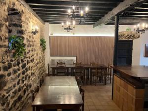 a restaurant with tables and chairs and a stone wall at LA CASONA DEL XERRON in El Condado