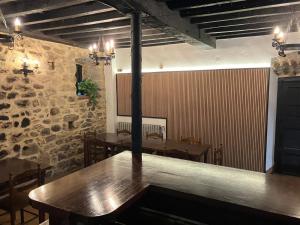 a dining room with tables and a stone wall at LA CASONA DEL XERRON in El Condado