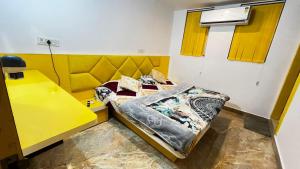a room with two beds and a yellow desk at The Ortus Suites by BnBGuys in Orchha