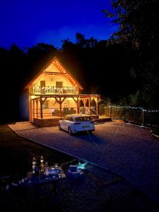 un coche aparcado delante de una casa por la noche en Forest Cottage 2024, en Lábatlan
