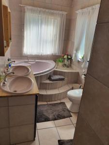 a bathroom with two sinks and a tub and a toilet at Moments and Memories house in East London +14 photos