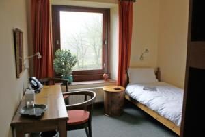 a room with a bed and a desk and a window at High Trenhouse in Settle