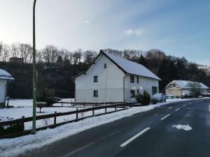 a white house on the side of a snowy road at Ruridylle IV in Simmerath
