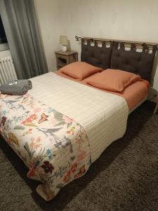 a bedroom with a large bed with orange pillows at Chambres d'hotes du Port Gautier in Vouvray-sur-Loir