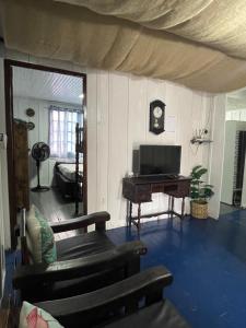 a living room with a television and a piano at Santo Gole Ilha Do Mel in Ilha do Mel