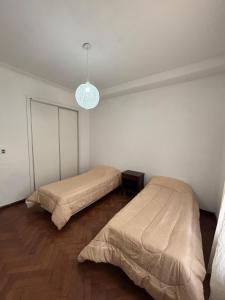 a bedroom with two beds and a light at Casa Moras in Necochea +3 photos