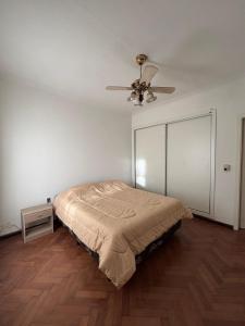 a bedroom with a bed and a ceiling fan at Casa Moras in Necochea