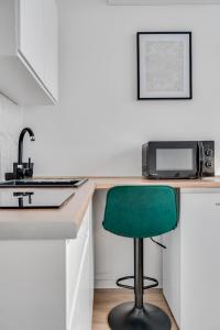 una cocina con una silla verde en un mostrador en Stylove Sunset, en Opole 2 fotos más
