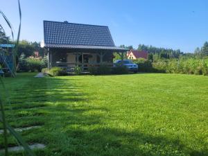 a house with a solar roof on top of a yard at Kajetanówka in Jackowo