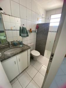 a bathroom with a toilet and a sink at Casa Aconchego Formosa em Praia de Formosa Cabedelo Paraíba in Cabedelo