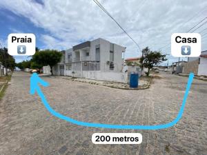 a picture of a house with a person in the street at Casa Aconchego Formosa em Praia de Formosa Cabedelo Paraíba in Cabedelo