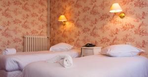 a room with two beds with towels on them at La Maison Normande in Trouville-sur-Mer