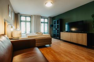 un soggiorno con divano e TV a schermo piatto di Luga Homes - Karli a Lipsia