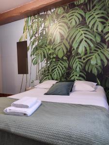 a bedroom with a bed with a plant wall at Hotel de la Place in Loyettes