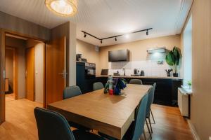 una sala da pranzo e una cucina con tavolo e sedie in legno di Luga Homes - Karli a Lipsia
