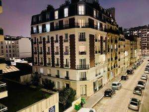 ein großes weißes Gebäude mit Autos auf einer Straße in der Unterkunft Appartement Maridor Porte de Versailles Paris in Paris