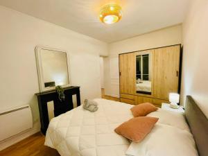 ein Schlafzimmer mit einem großen weißen Bett und einem Spiegel in der Unterkunft Appartement Maridor Porte de Versailles Paris in Paris