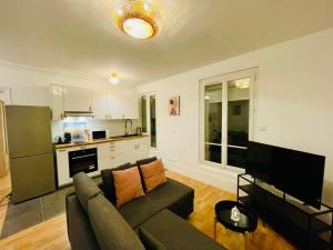 ein Wohnzimmer mit Couch und Küche in der Unterkunft Appartement Maridor Porte de Versailles Paris in Paris + 10 Fotos