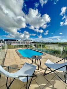 a patio with two chairs and a table and a pool at Rooftop Grand-Baie with private pool Ôfwewe in Grand Baie