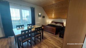 a bedroom with a bed and a table and chairs at Kapitański Dworek in Krynica Morska