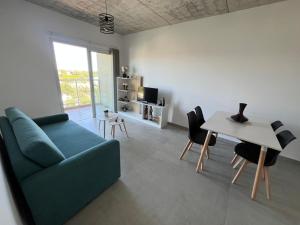 a living room with a green couch and a table at Depto Yrigoyen, opcional COCHERA a 20 metros in Rafaela