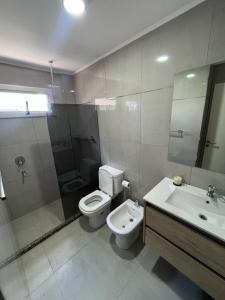a bathroom with a toilet and a sink and a mirror at Depto Yrigoyen in Rafaela +12 photos