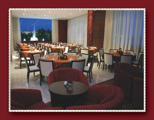 a dining room with tables and chairs in a restaurant at Master Plaza Hotel in Barbacena